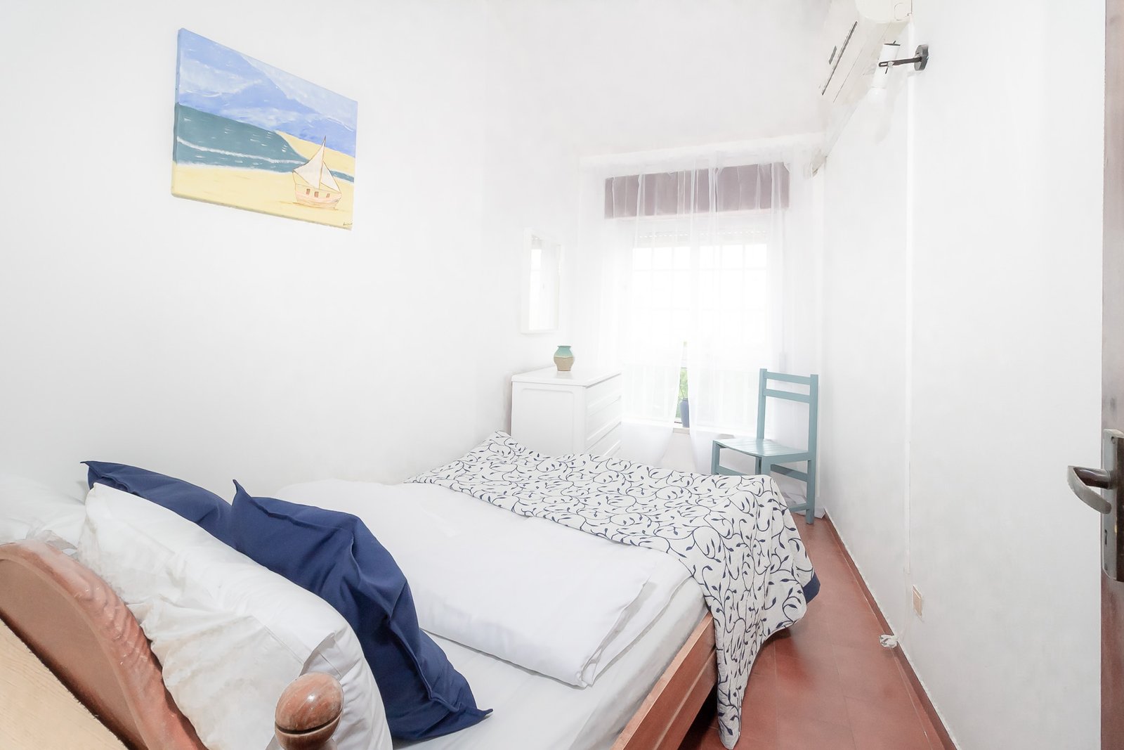 A second cozy bedroom with light linens and Algarve sun streaming in